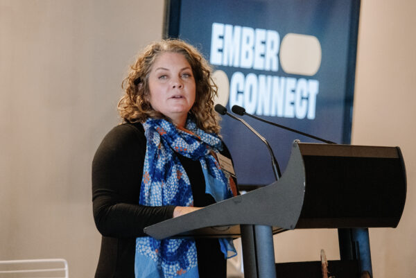 Ember Connect Culture and Membership Manager, Michelle Woosnam, stands at a lectern on stage
